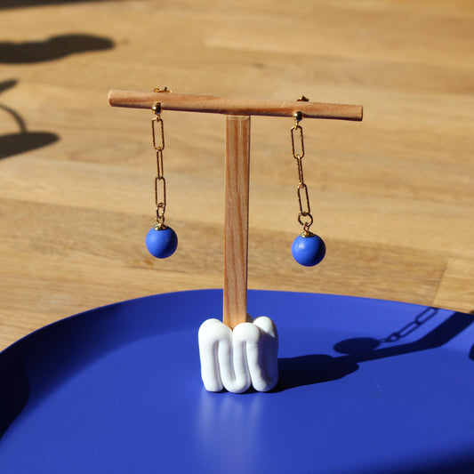 Hängeohrringe in Gold mit einer dunkelblauem runden Perle.