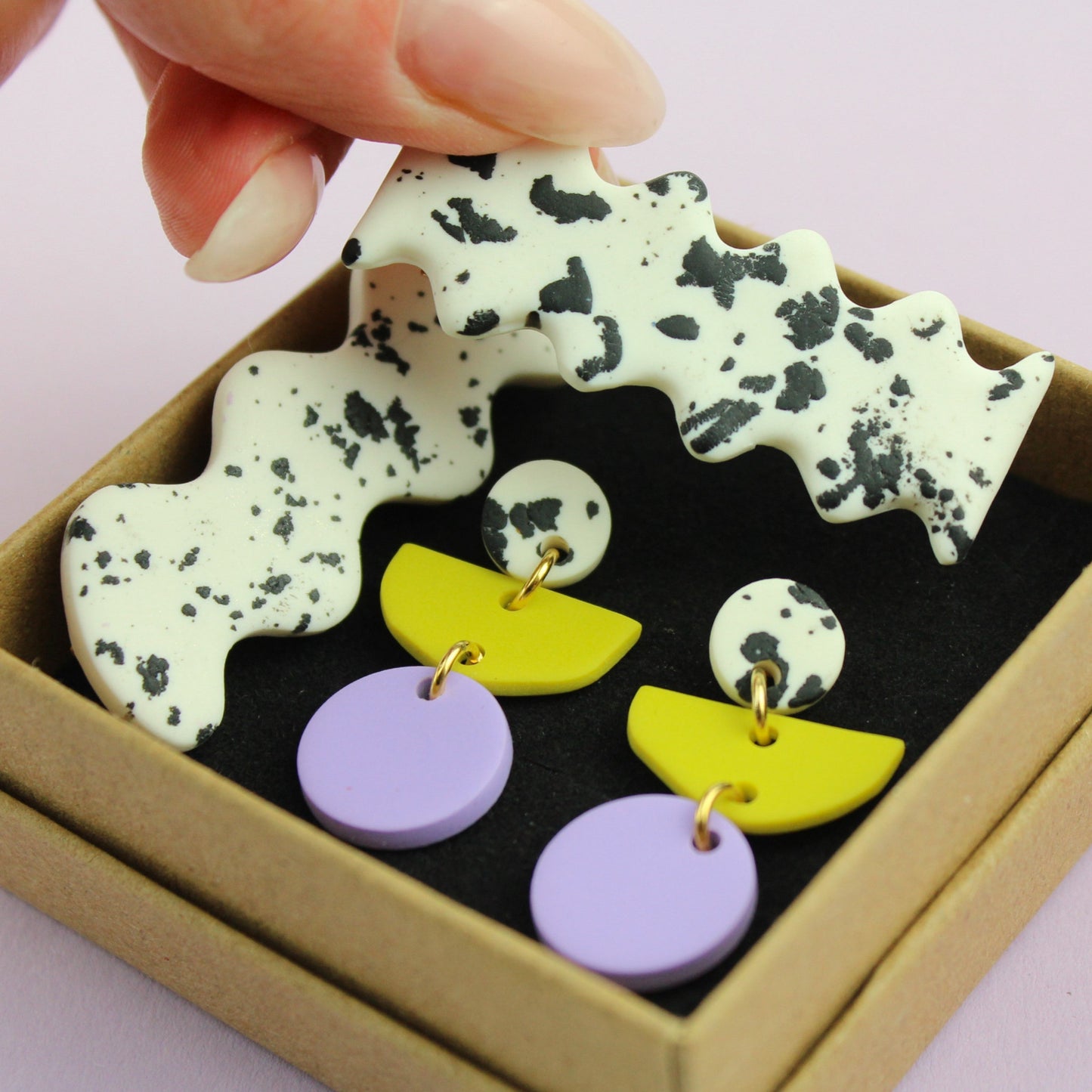 Ein handgemachtes Schmuck-Set bestehend aus einem Paar bunten Hängeohrringen und zwei passenden Haarspangen.