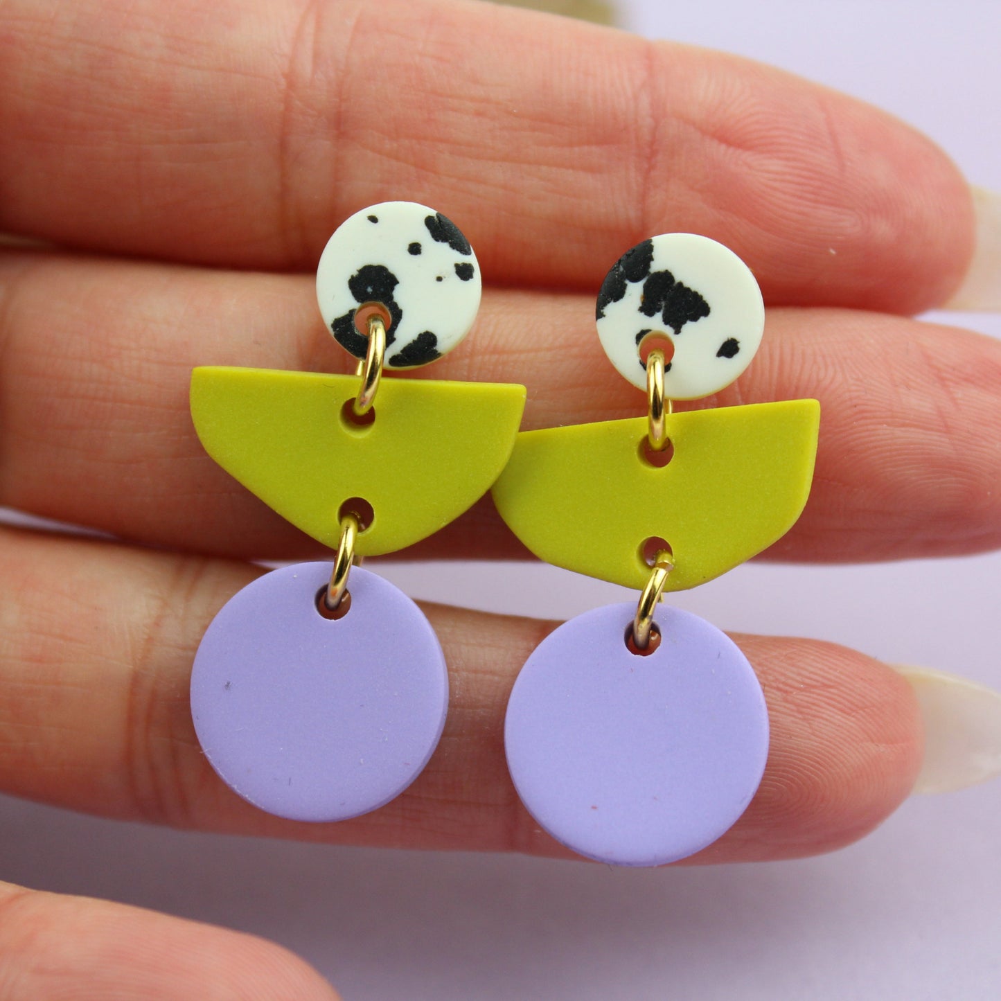 Ein handgemachtes Schmuck-Set bestehend aus einem Paar bunten Hängeohrringen und zwei passenden Haarspangen.