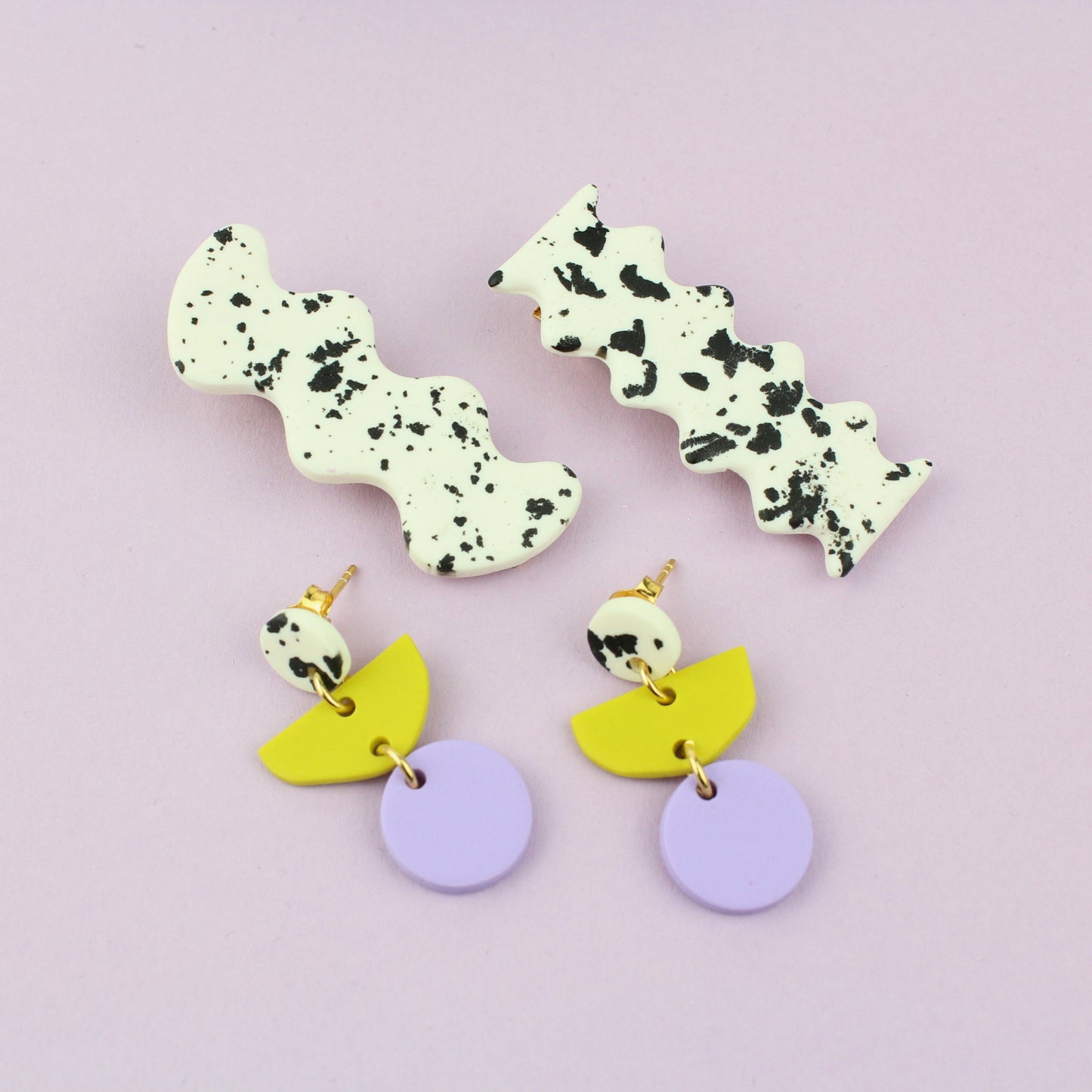 Ein handgemachtes Schmuck-Set bestehend aus einem Paar bunten Hängeohrringen und zwei passenden Haarspangen.