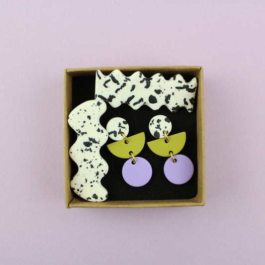 Ein handgemachtes Schmuck-Set bestehend aus einem Paar bunten Hängeohrringen und zwei passenden Haarspangen.