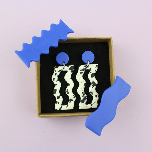 Ein handgemachtes Schmuck-Set bestehend aus einem Paar bunten Hängeohrringen und zwei passenden Haarspangen.