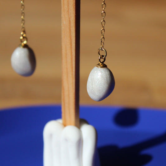 goldener hängender Kettenohrring mit einer handgeformten veganen Perle