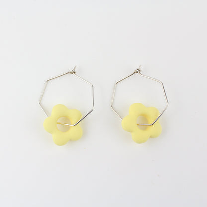 Sechseckige silberne Creole mit einem bunten Anhänger in Form einer Blume.
