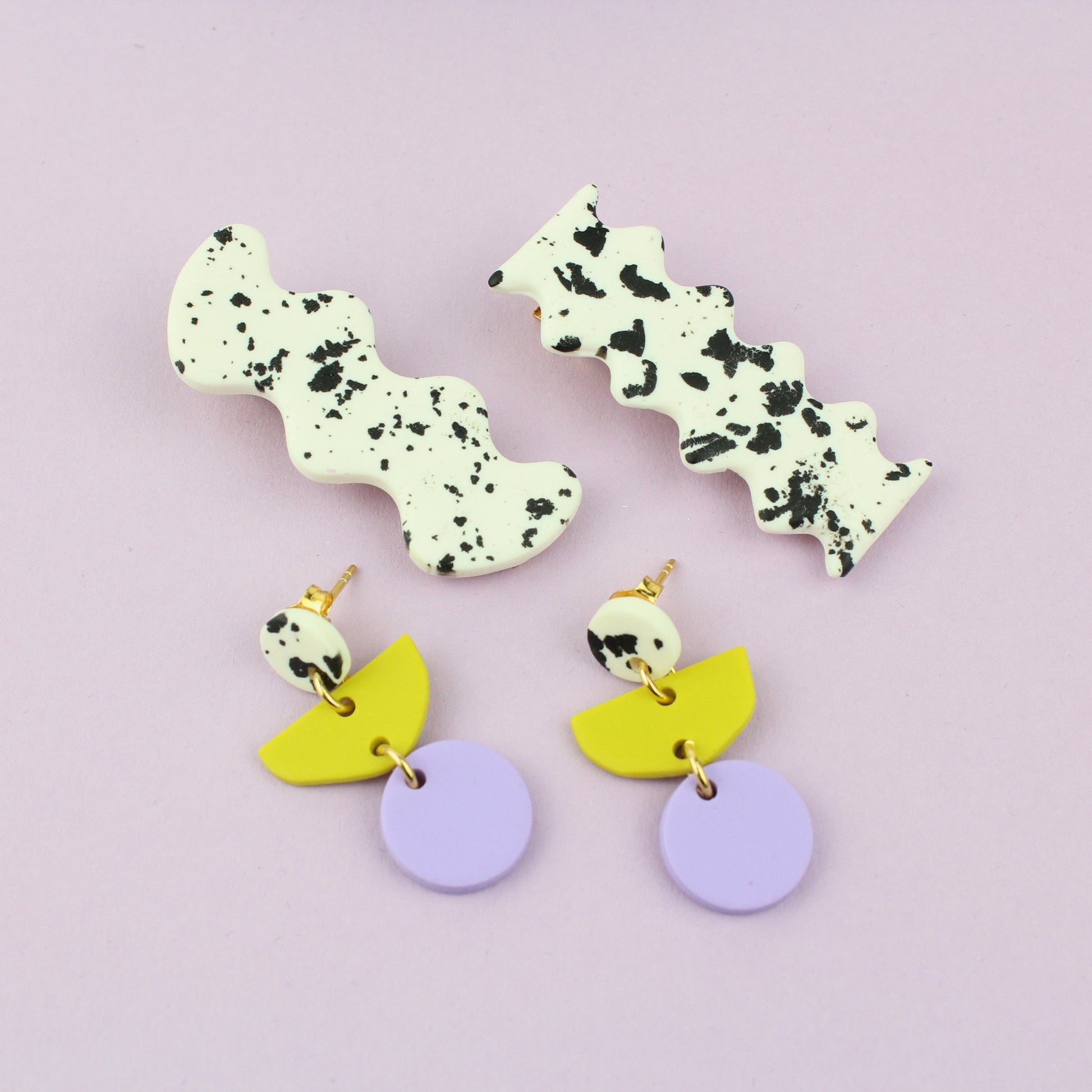 Ein handgemachtes Schmuck-Set bestehend aus einem Paar bunten Hängeohrringen und zwei passenden Haarspangen.
