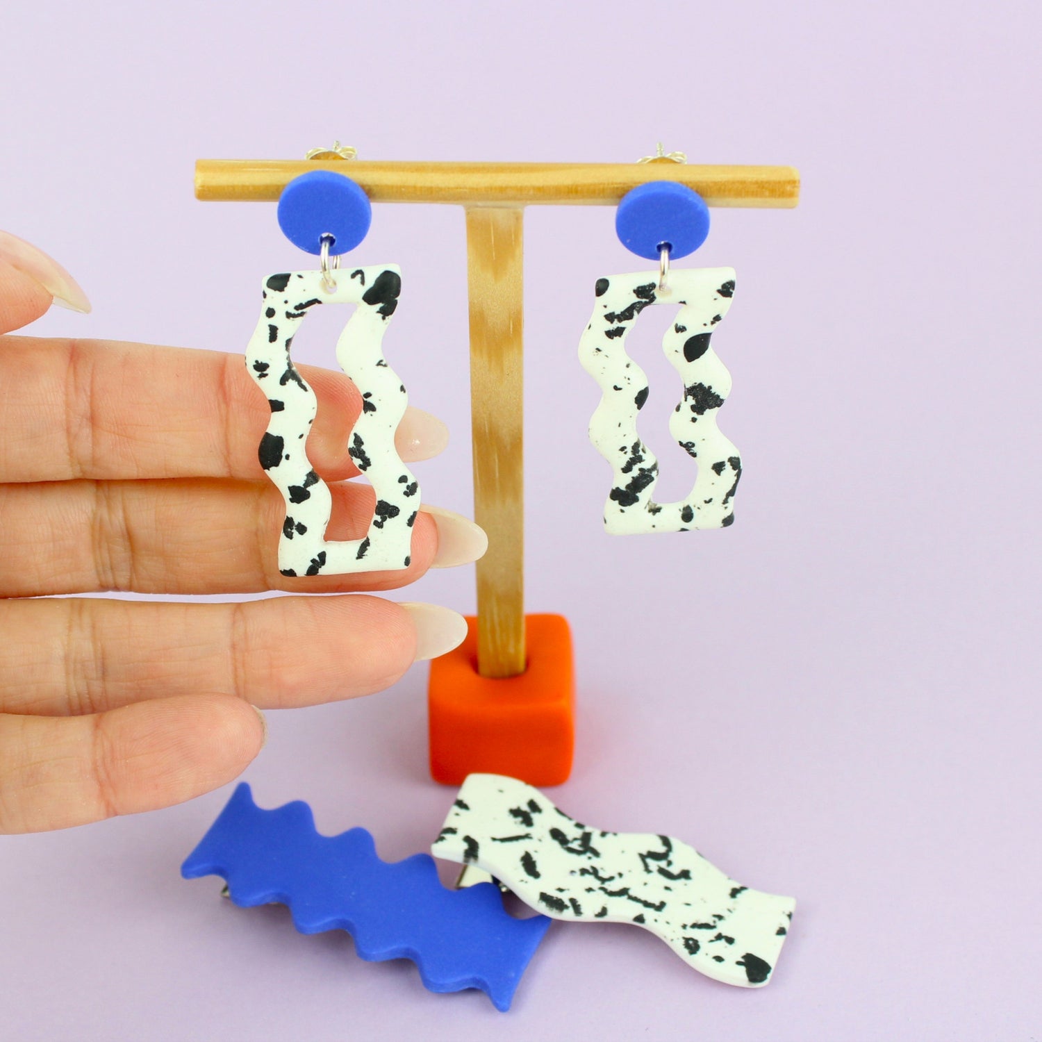 Ein handgemachtes Schmuck-Set bestehend aus einem Paar bunten Hängeohrringen und zwei passenden Haarspangen.
