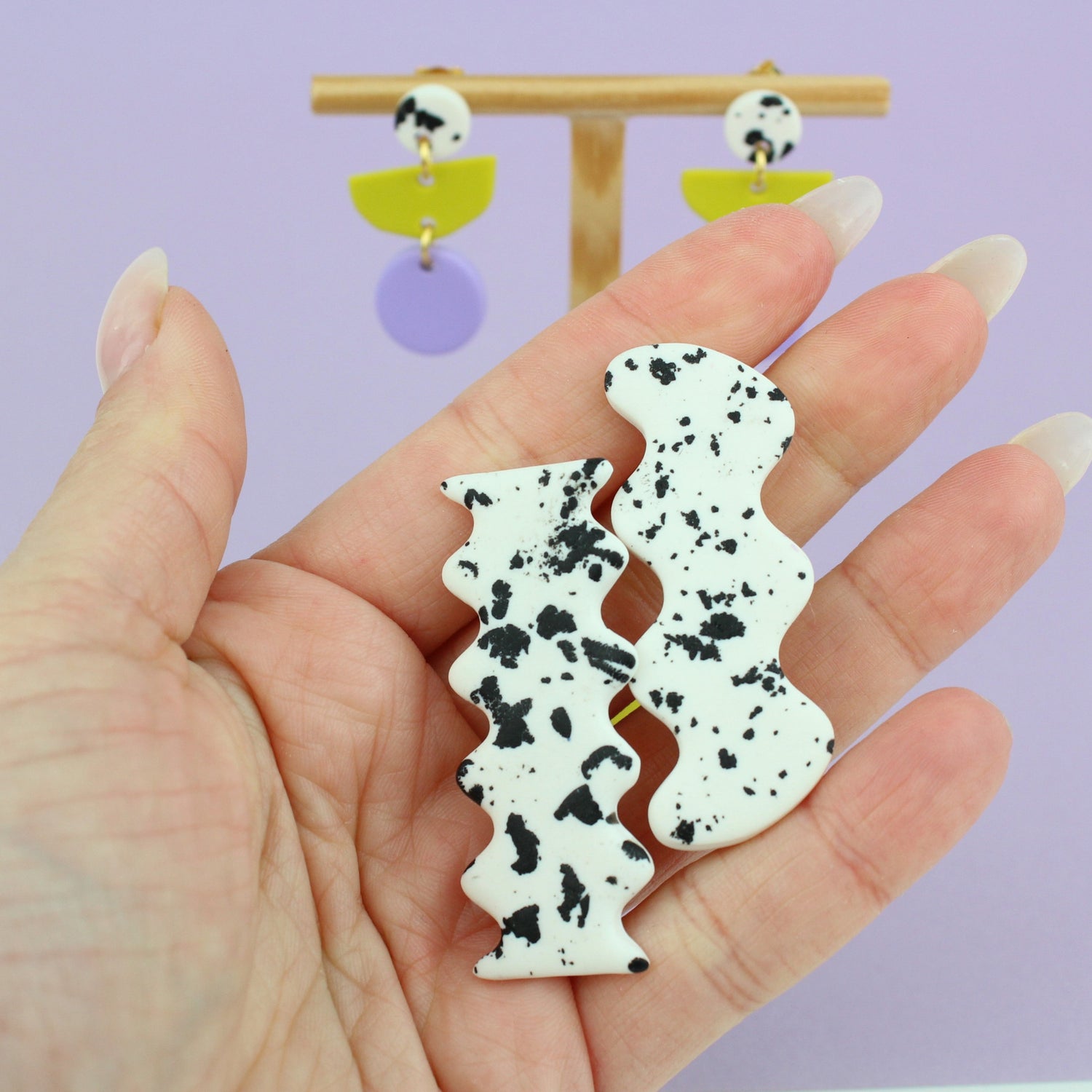 Ein handgemachtes Schmuck-Set bestehend aus einem Paar bunten Hängeohrringen und zwei passenden Haarspangen.